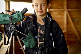 Ben in a bird hide with a telescope