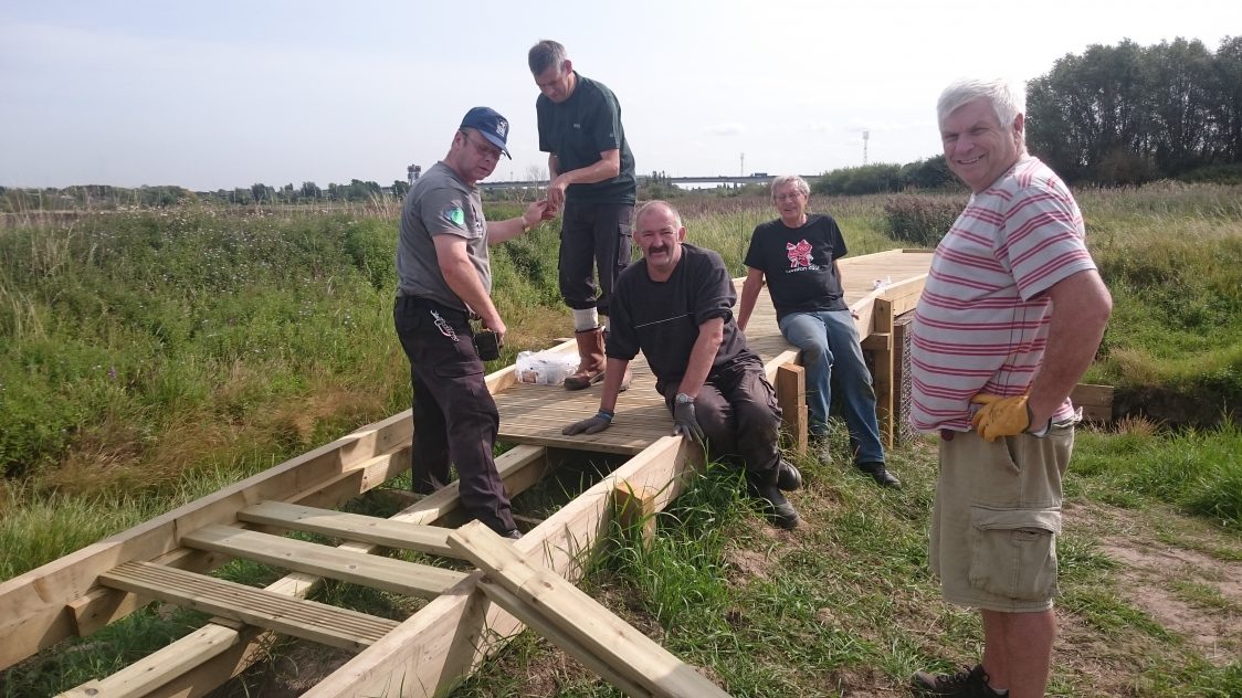 Group of male volunteers constructing a viewing platform.